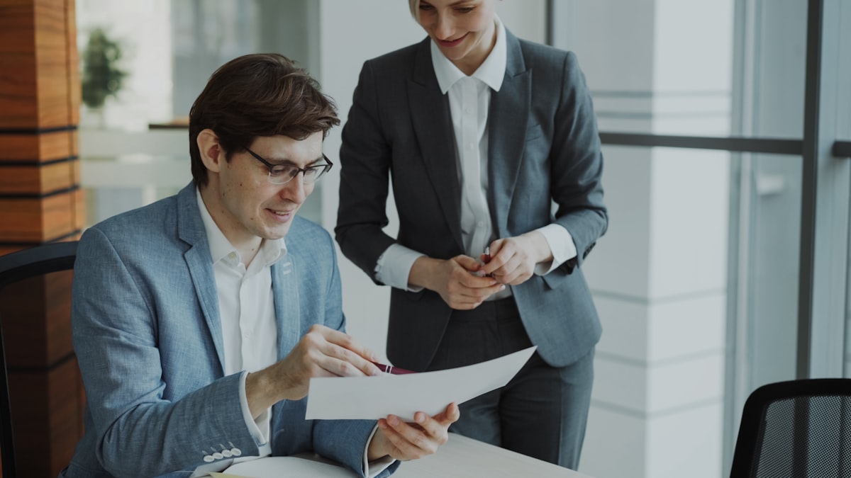 Two professionals reviewing a document together in a modern office